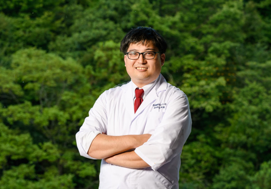 画像:腕を組んで笑顔でこちらを見ている社員